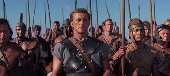 Movie still from “Spartacus” (1960), directed by Stanley Kubrick – A group of men are marching in a line; Medium shot, Low angle