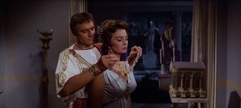 Movie still from “Spartacus” (1960), directed by Stanley Kubrick – A man and a woman in roman garb looking at a necklace; Medium shot, Over the shoulder angle