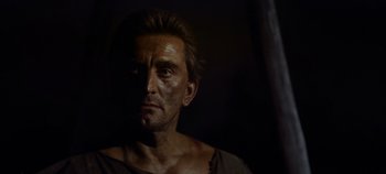 Movie still from “Spartacus” (1960), directed by Stanley Kubrick – A person wearing a shirt with dirt on them; Close Up shot, Low angle