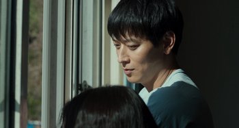 Movie still from “Broker” (2022), directed by Kore-eda Hirokazu – A man and a woman looking out of a window; Close Up shot, Over the shoulder angle