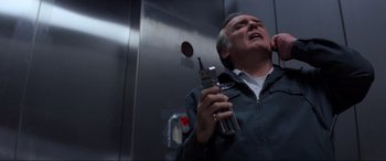 Movie still from “Speed” (1994), directed by Jan de Bont – An older man holding a cell phone up to his ear; Close Up shot, Low angle