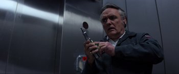 Movie still from “Speed” (1994), directed by Jan de Bont – A man holding a cell phone in his hands; Close Up shot, Low angle