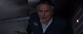 Movie still from “Speed” (1994), directed by Jan de Bont – An older man with gray long hair and gray eyes; Close Up shot, Overhead angle