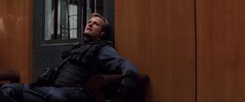 Movie still from “Speed” (1994), directed by Jan de Bont – A man sitting on a chair with his eyes closed; Medium shot, High angle