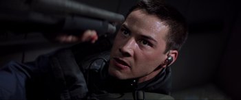 Movie still from “Speed” (1994), directed by Jan de Bont – A person wearing headphones and holding a gun; Close Up shot, Low angle