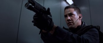 Movie still from “Speed” (1994), directed by Jan de Bont – A man holding a gun while wearing black gloves; Close Up shot, Low angle