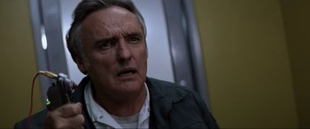 Movie still from “Speed” (1994), directed by Jan de Bont – An older man with gray hair is looking at the camera; Close Up shot, Low angle