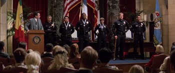 Movie still from “Speed” (1994), directed by Jan de Bont – A group of police officers standing in front of an audience; Wide shot, High angle