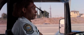 Movie still from “Speed” (1994), directed by Jan de Bont – A police officer looking out the window of a car; Close Up shot, Low angle