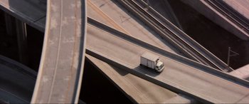 Movie still from “Speed” (1994), directed by Jan de Bont – An aerial view of a truck driving on a highway; Extreme Wide shot, Overhead angle
