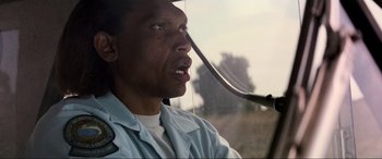 Movie still from “Speed” (1994), directed by Jan de Bont – A person driving a car; Close Up shot, Low angle