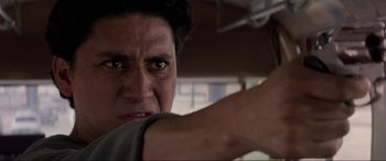 Movie still from “Speed” (1994), directed by Jan de Bont – A person with a gun pointed at the camera; Close Up shot, Low angle