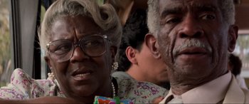 Movie still from “Speed” (1994), directed by Jan de Bont – A person wearing glasses and a floral shirt; Close Up shot, Low angle