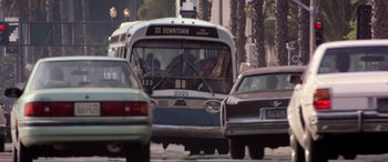 Movie still from “Speed” (1994), directed by Jan de Bont – A city bus driving down a street next to parked cars; Extreme Wide shot, Low angle