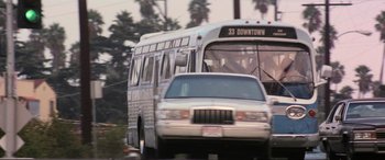 Movie still from “Speed” (1994), directed by Jan de Bont – A bus and a car on the road; Wide shot, Low angle