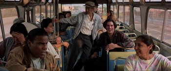 Movie still from “Speed” (1994), directed by Jan de Bont – An old man standing on the side of a bus; Wide shot, Over the shoulder angle