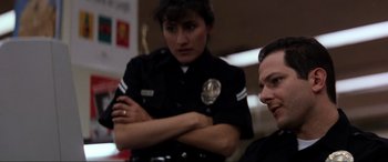Movie still from “Speed” (1994), directed by Jan de Bont – A police officer standing next to another officer; Close Up shot, Low angle