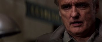 Movie still from “Speed” (1994), directed by Jan de Bont – An older man in a gray jacket looking at the camera; Close Up shot, Low angle