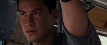 Movie still from “Speed” (1994), directed by Jan de Bont – A man's face with another man in the background; Close Up shot, Over the shoulder angle
