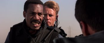 Movie still from “Speed” (1994), directed by Jan de Bont – A man and a woman are standing next to each other; Close Up shot, Low angle