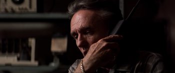 Movie still from “Speed” (1994), directed by Jan de Bont – A person talking on a phone; Close Up shot, Low angle