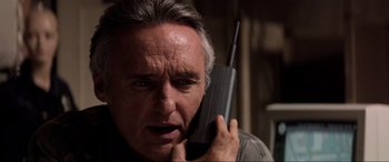 Movie still from “Speed” (1994), directed by Jan de Bont – An older man holding a cell phone to his ear; Close Up shot, Low angle