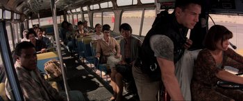 Movie still from “Speed” (1994), directed by Jan de Bont – A group of people riding on a bus; Wide shot, Over the shoulder angle