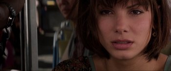 Movie still from “Speed” (1994), directed by Jan de Bont – A woman's face with a man behind her; Close Up shot, Over the shoulder angle