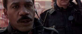 Movie still from “Speed” (1994), directed by Jan de Bont – A person wearing a headset; Close Up shot, Low angle