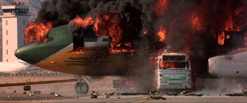 Movie still from “Speed” (1994), directed by Jan de Bont – An airplane is burning in the middle of a field; Extreme Wide shot, High angle