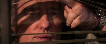 Movie still from “Speed” (1994), directed by Jan de Bont – An older man looking out a window through blinds; Extreme Close Up shot, Low angle