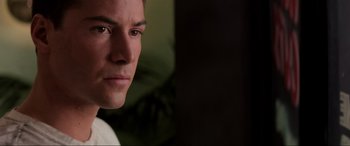 Movie still from “Speed” (1994), directed by Jan de Bont – A man's face in front of a dark background; Close Up shot, Over the shoulder angle