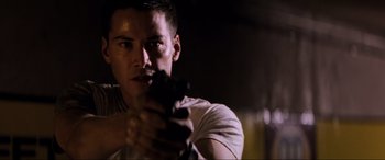 Movie still from “Speed” (1994), directed by Jan de Bont – A man holding a gun in his hand; Close Up shot, Low angle