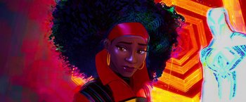 Movie still from “Spider-Man: Across the Spider-Verse” (2023), directed by Joaquim Dos Santos – A woman in a red jacket with a large afro; Close Up shot, Over the shoulder angle