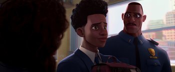 Movie still from “Spider-Man: Across the Spider-Verse” (2023), directed by Joaquim Dos Santos – A man with a curly afro is looking at the camera; Close Up shot, Over the shoulder angle