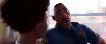 Movie still from “Spider-Man: Across the Spider-Verse” (2023), directed by Joaquim Dos Santos – A man in a police uniform talking to another man; Close Up shot, Over the shoulder angle