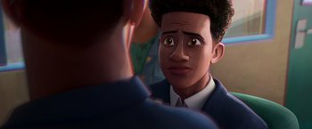 Movie still from “Spider-Man: Across the Spider-Verse” (2023), directed by Joaquim Dos Santos – An animated character looking at a person in a suit; Close Up shot, Over the shoulder angle