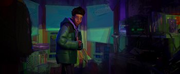 Movie still from “Spider-Man: Across the Spider-Verse” (2023), directed by Joaquim Dos Santos – A man in a green jacket standing in front of a table; Medium shot, High angle