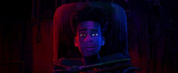 Movie still from “Spider-Man: Across the Spider-Verse” (2023), directed by Joaquim Dos Santos – A young boy is sitting in a chair; Close Up shot, Overhead angle