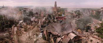 Movie still from “Spider-Man: Far from Home” (2019), directed by Jon Watts – An aerial view of a destroyed city with smoke billowing from it; Extreme Wide shot, High angle