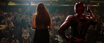 Movie still from “Spider-Man: Far from Home” (2019), directed by Jon Watts – A woman standing in front of an audience with a microphone; Medium shot, Over the shoulder angle