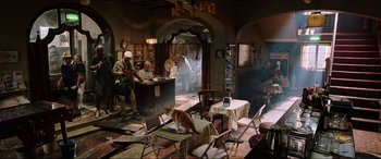 Movie still from “Spider-Man: Far from Home” (2019), directed by Jon Watts – A cat sitting on a table in a room with chairs; Wide shot, High angle