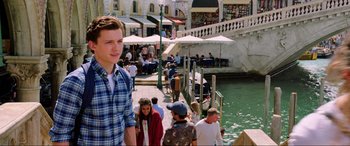 Movie still from “Spider-Man: Far from Home” (2019), directed by Jon Watts – A group of people standing on a dock near a body of water; Medium shot, Over the shoulder angle