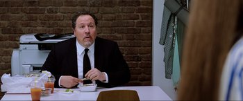 Movie still from “Spider-Man: Far from Home” (2019), directed by Jon Watts – A man sitting at a table with food in front of him; Close Up shot, Low angle