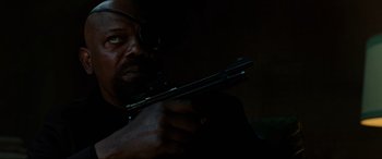 Movie still from “Spider-Man: Far from Home” (2019), directed by Jon Watts – A man holding a gun in a dark room; Close Up shot, Low angle