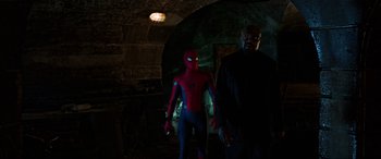 Movie still from “Spider-Man: Far from Home” (2019), directed by Jon Watts – A man and a spider - man in a dark room; Wide shot, Over the shoulder angle