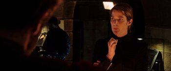 Movie still from “Spider-Man: Far from Home” (2019), directed by Jon Watts – A man standing in a dark room with his hand on his chin; Close Up shot, Over the shoulder angle