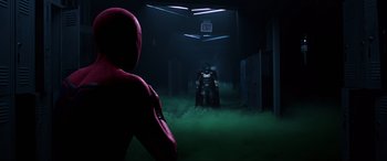 Movie still from “Spider-Man: Far from Home” (2019), directed by Jon Watts – A man in a batman costume in a dark room; Wide shot, Over the shoulder angle