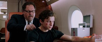 Movie still from “Spider-Man: Far from Home” (2019), directed by Jon Watts – A man and a boy are sitting next to each other on a plane; Close Up shot, Over the shoulder angle