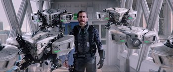 Movie still from “Spider-Man: Far from Home” (2019), directed by Jon Watts – A man standing in a room surrounded by robots; Medium shot, Low angle